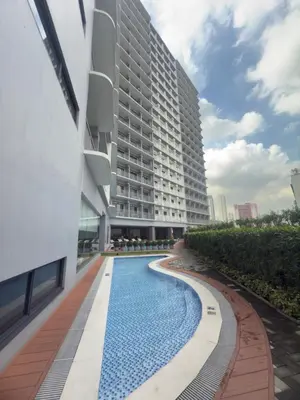 a swimming pool in front of a building at MAKATI - Lush Residences in Manila