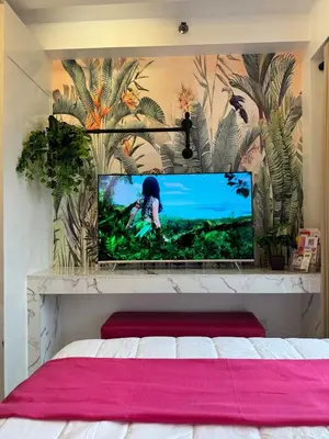 a bedroom with a flat screen tv above a bed at Shore Residences Sunset Room facing Manila Bay & City View RM1641 by Prime Stay MOA in Manila