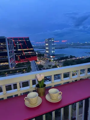 two cups and saucers on a balcony with a city skyline at Shore Residences Sunset Room facing Manila Bay & City View RM1641 by Prime Stay MOA in Manila