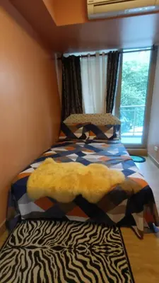 a bedroom with a bed with a zebra blanket and a window at Joy Azure Escapes in Manila