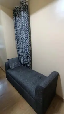 a blue couch sitting in the corner of a room at Joy Azure Escapes in Manila