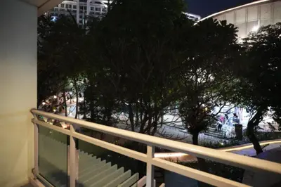 a balcony with a white railing and some trees at Joy Azure Escapes in Manila