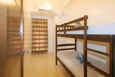 a bunk bed room with two bunk beds and a door at Stay Manila Hotel by RedDoorz in Manila