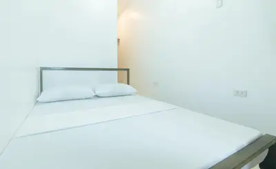 a white bed with two white pillows on it at Stay Manila Hotel by RedDoorz in Manila