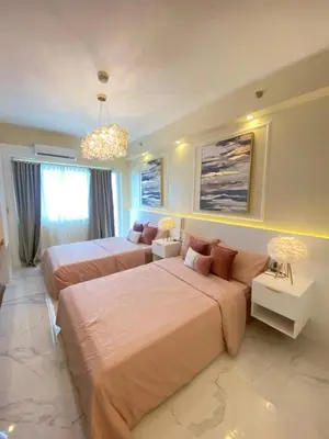 a bedroom with two beds and a couch at Fairy Dust Sky Suite By Crib2GO in Manila