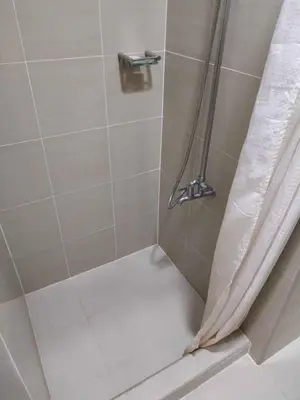 a shower with a shower curtain in a bathroom at Shore Residence Tower 3 in Manila
