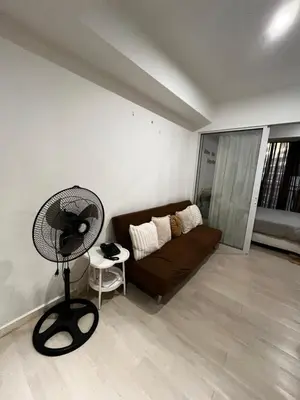 a living room with a couch and a fan at Azure Condo Maui 1 bedroom in Manila