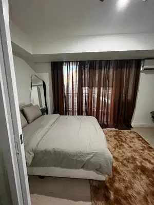a bedroom with a bed and a large window at Azure Condo Maui 1 bedroom in Manila