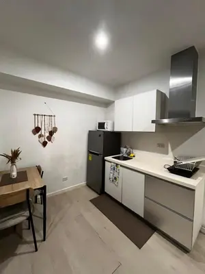 a kitchen with white cabinets and a table in it at Azure Condo Maui 1 bedroom in Manila