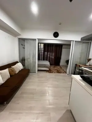 a living room with a couch and a kitchen at Azure Condo Maui 1 bedroom in Manila