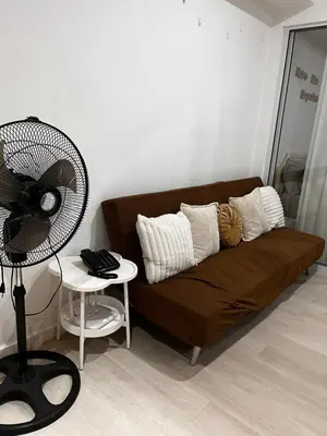 a couch with pillows and a fan in a room at Azure Condo Maui 1 bedroom in Manila