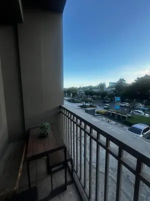 a balcony with a table and a view of a parking lot at Shore Staycation near Moa & Airport in Manila