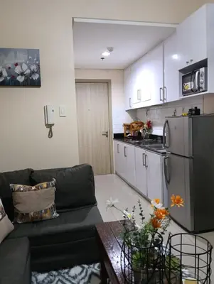 a living room with a couch and a kitchen at Shore Staycation near Moa & Airport in Manila