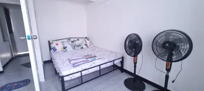 a room with a chair and a fan at Affordable accommodation near NAIA, MOA and BGC in Manila