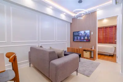 a living room with a couch and a tv at Éire Home Stay in Manila