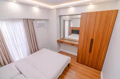 a small bedroom with a bed and a mirror at Éire Home Stay in Manila