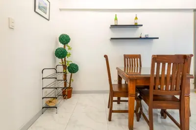 a dining room with a wooden table and two chairs at Forbeswood Heights BGC suite near st Lukes in Manila