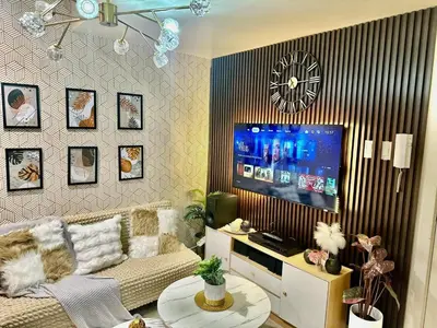 a living room with a couch and a flat screen tv at AZURE BICUTAN -MIAMI TOWER 6 Floor in Manila