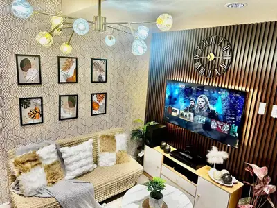 a living room with a couch and a flat screen tv at AZURE BICUTAN -MIAMI TOWER 6 Floor in Manila