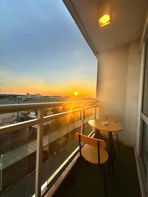 a balcony with a table and chairs and a sunset at AZURE BICUTAN -MIAMI TOWER 6 Floor in Manila