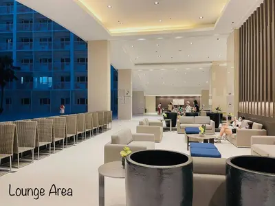 a lobby of a hotel with people sitting in chairs at Modern Double-Sized Bed with Netflix & Pool View in Manila