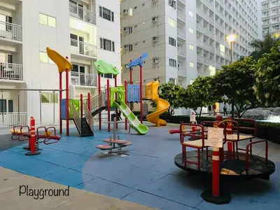 a playground with a slide in a city at Modern Double-Sized Bed with Netflix & Pool View in Manila
