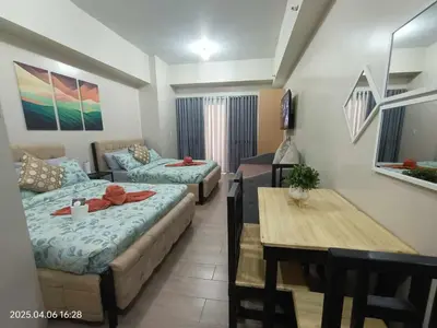 a room with a bed and a table and a couch at 81 Newport Boulevard across Manila Airport NAIA T3 in Manila