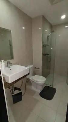 a bathroom with a sink and a toilet and a shower at 81 Newport Boulevard across Manila Airport NAIA T3 in Manila