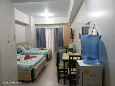 a room with two beds and a table with a blue container at 81 Newport Boulevard across Manila Airport NAIA T3 in Manila