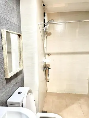 a bathroom with a shower and a toilet at Cozy studio near Eastwood QC in Manila