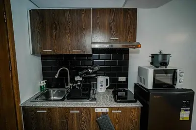 a small kitchen with a sink and a microwave at TahananStays at Makati CBD in Manila