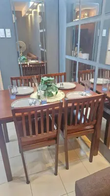 a dining room table with two chairs and a table with plates at 1BR with Prime Netflix, Disney HBO max in Manila