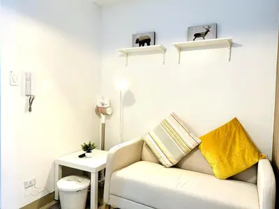 a white living room with a couch and a table at FT1161 House in Manila