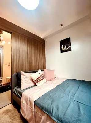 a bedroom with a large bed with pillows on it at JR864 House in Manila