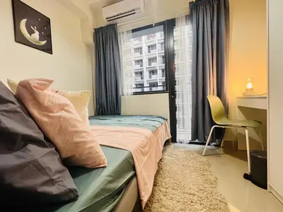 a small bedroom with a bed and a window at JR864 House in Manila