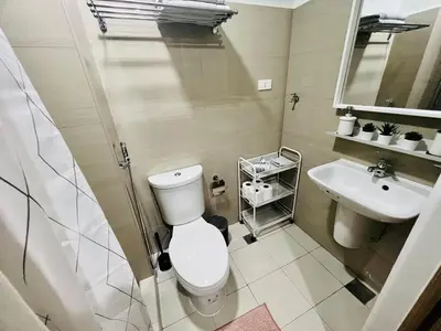 a bathroom with a toilet and a sink at JR864 House in Manila