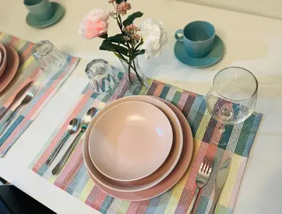 a table set with a plate and a vase with flowers at JR864 House in Manila