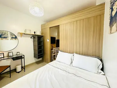 a bedroom with a bed and a table and a mirror at MK1661 House in Manila