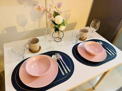 a table with two pink plates and a vase with flowers at MK1661 House in Manila