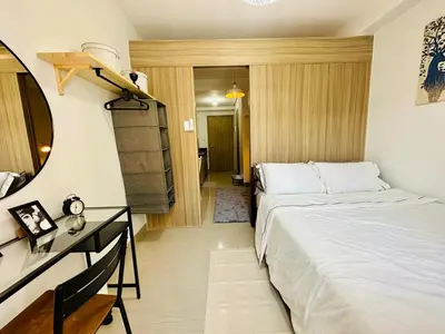 a bedroom with a bed and a desk and a mirror at MK1661 House in Manila