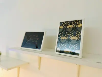 two framed photographs sitting on a white shelf at MK1661 House in Manila