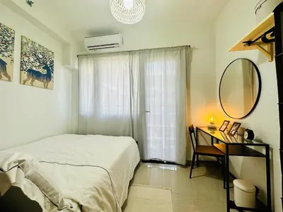 a bedroom with a bed and a desk with a mirror at MK1661 House in Manila