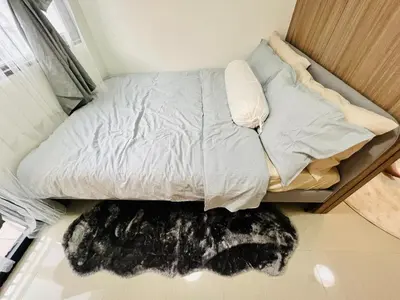 a bed with a furry rug on the floor at TM1410 House in Manila