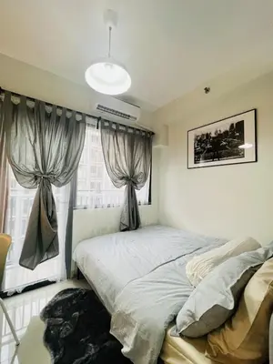 a bedroom with a bed and a window with curtains at TM1410 House in Manila