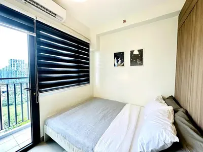 a bedroom with a bed and a window with blinds at OREO1232 House in Manila