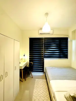 a bedroom with a bed and a desk and a window at OREO1232 House in Manila