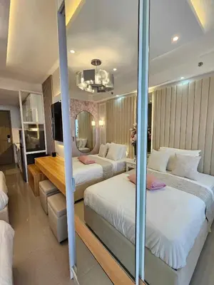 a hotel room with two beds and a mirror at Graceful Getaway Suites in Manila