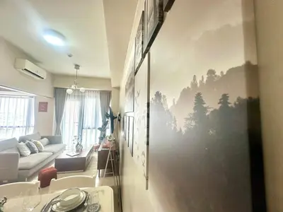 a living room with a painting on the wall at Cozy 1BR at Greenbelt Hamilton Makati in Manila