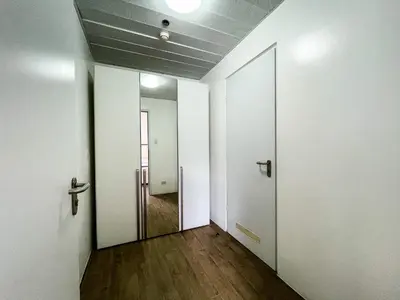 an empty hallway with an open door and wooden floors at Full-Serviced Residential Apartment in Uptown, BGC in Manila