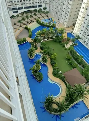 arial view of a resort with blue water and palm trees at Carps Staycation in Manila